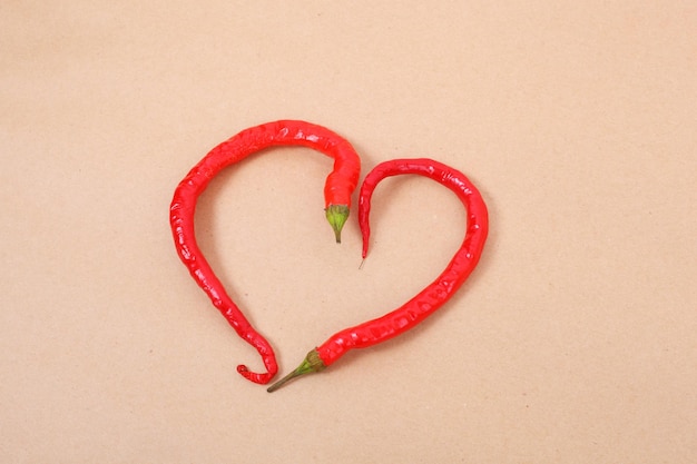 Piment rouge en forme de coeur sur fond artisanal