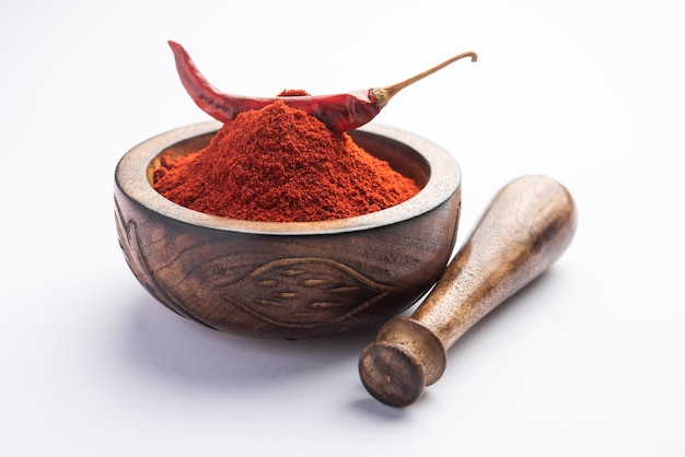 Piment rouge ou Lal Mirchi ou mirch avec de la poudre dans un bol ou un mortier sur fond de mauvaise humeur, mise au point sélective