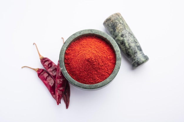 Piment rouge ou Lal Mirchi ou mirch avec de la poudre dans un bol ou un mortier sur fond de mauvaise humeur, mise au point sélective