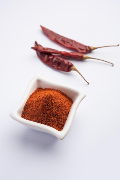 Piment rouge ou Lal Mirchi ou mirch avec de la poudre dans un bol ou un mortier sur fond de mauvaise humeur, mise au point sélective