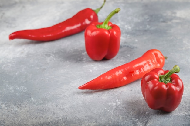 Piment rouge et poivrons doux placés sur une surface en marbre