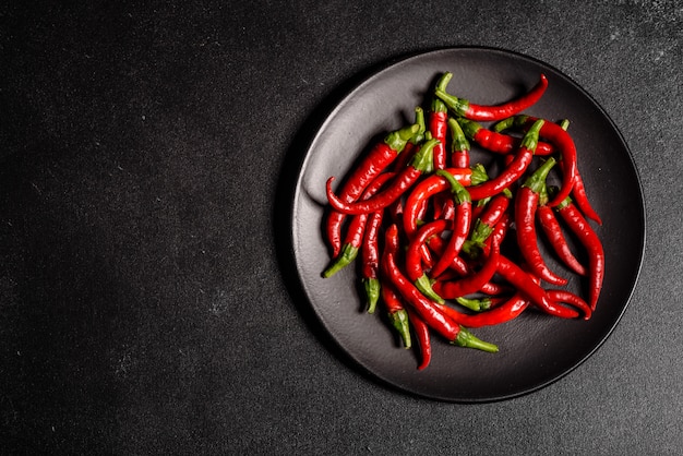 Piment rouge vif sur un béton gris. Nourriture épicée, ingrédients