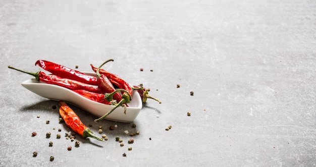 Piment sec dans une tasse sur table en béton.