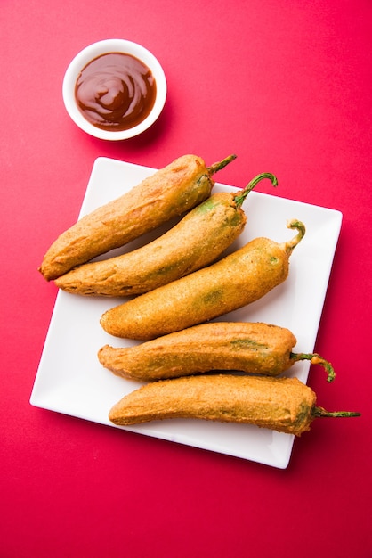 Piment vert croustillant Pakora ou Mirchi Bajji, servi avec du ketchup aux tomates sur fond de mauvaise humeur. C'est une collation populaire à l'heure du thé en Inde, en particulier à la mousson. Mise au point sélective