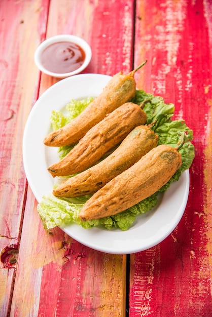 Piment vert croustillant Pakora ou Mirchi Bajji, servi avec du ketchup aux tomates sur fond de mauvaise humeur. C'est une collation populaire à l'heure du thé en Inde, en particulier à la mousson. Mise au point sélective