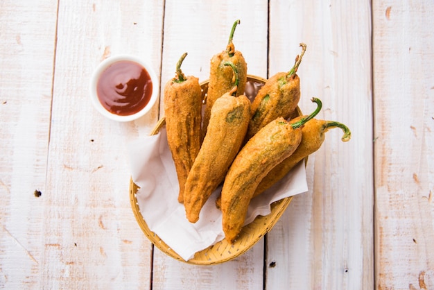 Piment vert croustillant Pakora ou Mirchi Bajji, servi avec du ketchup aux tomates sur fond de mauvaise humeur. C'est une collation populaire à l'heure du thé en Inde, en particulier à la mousson. Mise au point sélective