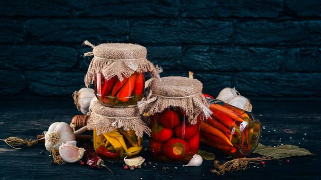 Piments chili marinés dans un bocal Stocks de nourriture Vue de dessus Sur un fond en bois Copiez l'espace