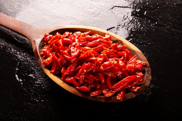 piments forts en cuillère blanche sur fond noird, terme latin Capsicum frutescens, Malagueta.