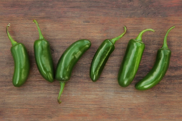 Piments jalapeno verts frais sur une table en bois à plat