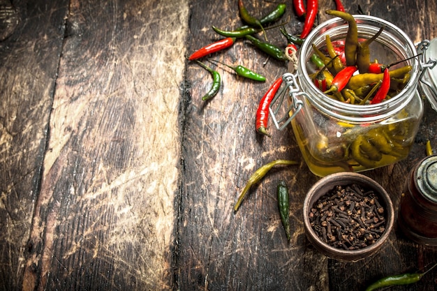 Piments marinés aux épices. Sur un fond en bois.