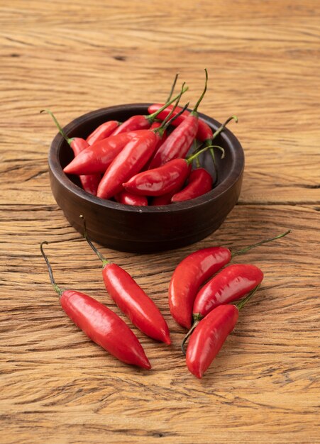 Piments rouges sur un bol au-dessus d'une table en bois