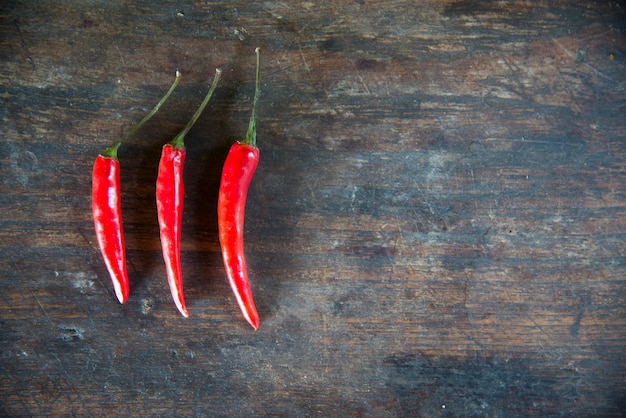 Piments rouges chauds sur le fond de la table en bois