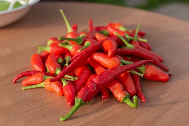 Piments rouges chauds sur une vieille table en bois