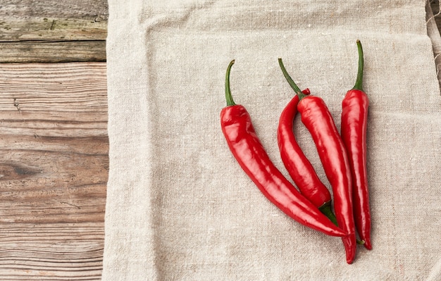 Piments rouges crus sur une serviette en lin gris