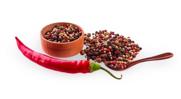 Piments rouges avec cuillère à mesurer en bois et tasse avec poivre de couleur