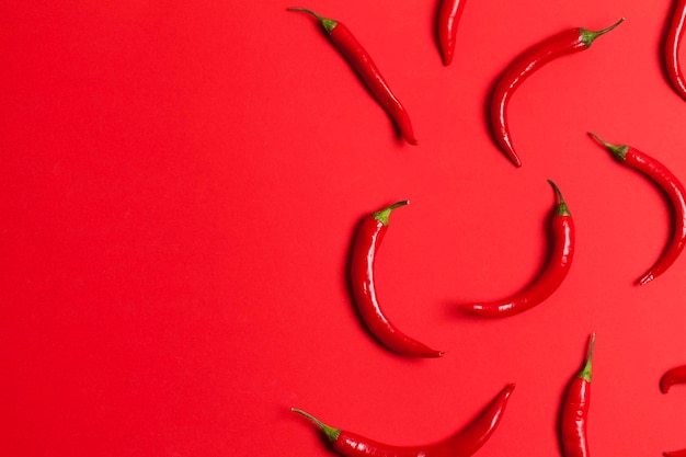 Piments rouges disposés sur un fond rouge vif