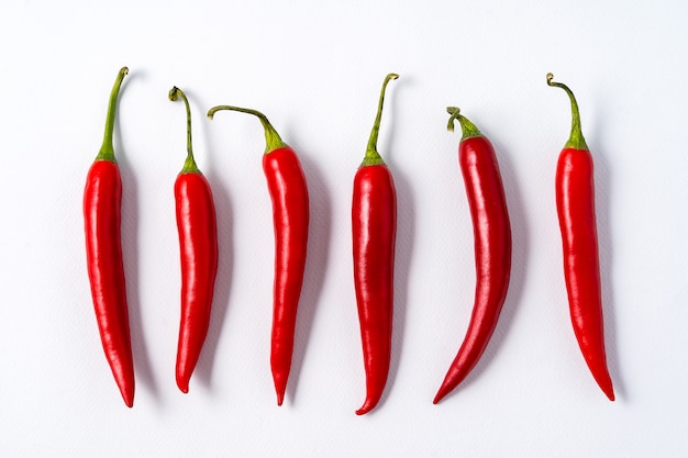 Piments rouges épicés au piment rouge sur fond blanc.