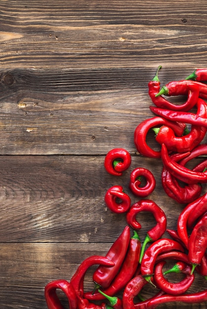 Piments rouges frais bio sur une surface en bois rustique. Vue de dessus.