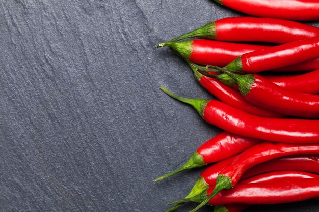 Piments rouges frais sur un fond d'ardoise sombre