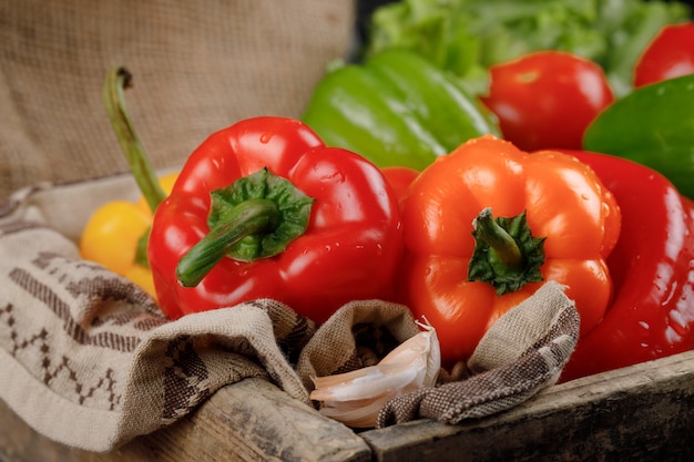 Piments rouges et orange sur plateau en bois.