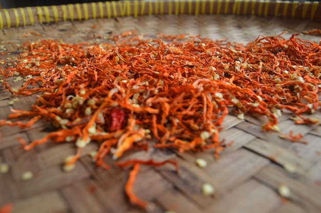 Des piments rouges séchés sur un plateau en bambou