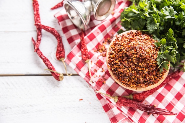 Piments séchés et broyés dans des bols en bois avec des herbes de persil.