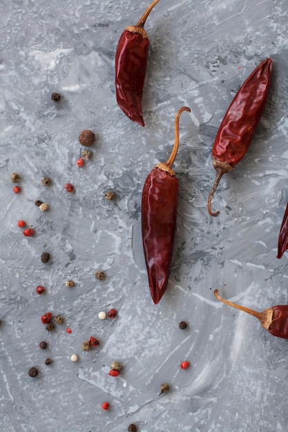 Piments secs séchés rouges de poivre et de poivre en grains sur un fond gris vintage