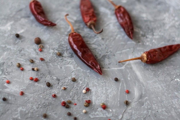 Piments secs séchés rouges de poivre et de poivre en grains sur un fond gris vintage