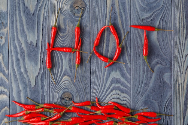 Piments sur table en bois formant le mot chaud