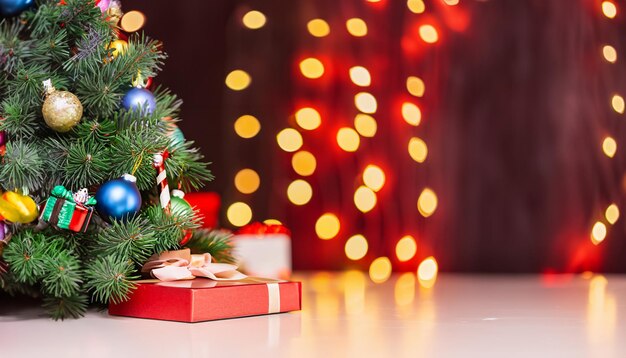Pin de Noël traditionnel avec décorations de vacances sur fond et pile de cadeaux