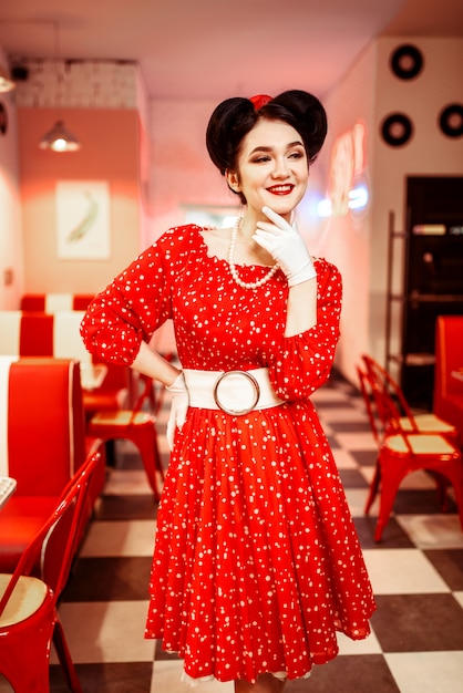 Pin up femme en robe rouge à pois blancs