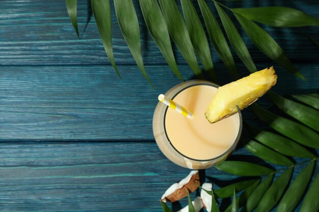 Pina colada cocktail sur table en bois bleu.