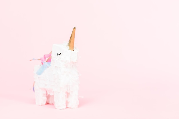 Pinata licorne blanche sur fond rose.