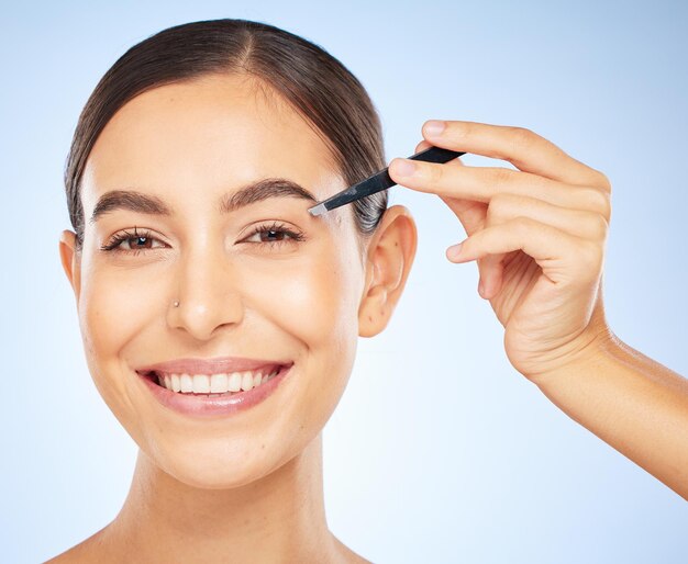 Pince à épiler de beauté et portrait de femme sur fond bleu toilettage du visage et épilation professionnelle salon de spa et soins de la peau femme heureuse épilant ou épilant les cheveux des sourcils