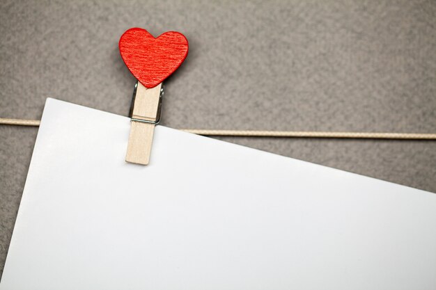 Pince à linge décorative avec coeur et drap vide blanc suspendu à une corde