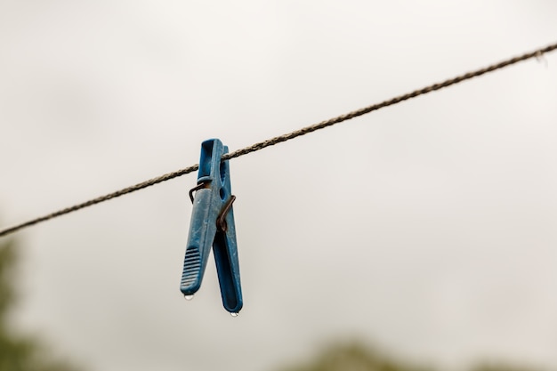 Pince à linge suspendue à une corde une pince à linge est suspendue à la corde à linge arrière-plan flou