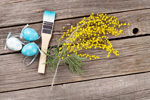 Pinceau coloré d'oeufs de pâques et fleur de mimosa