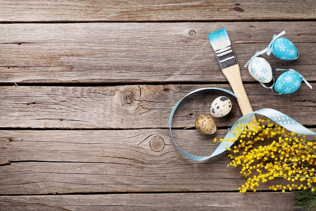 Pinceau coloré d'oeufs de pâques et fleur de mimosa