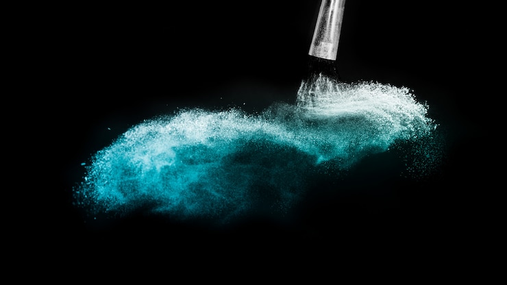 Photo pinceau cosmétique avec épandage de poudre cosmétique bleue