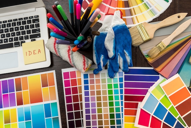 Pinceau et gants pour ordinateur portable et palette de couleurs pour votre maison de conception au bureau