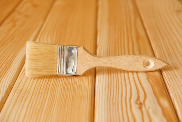 Pinceau à poils et manche en bois sur des planches en bois naturel