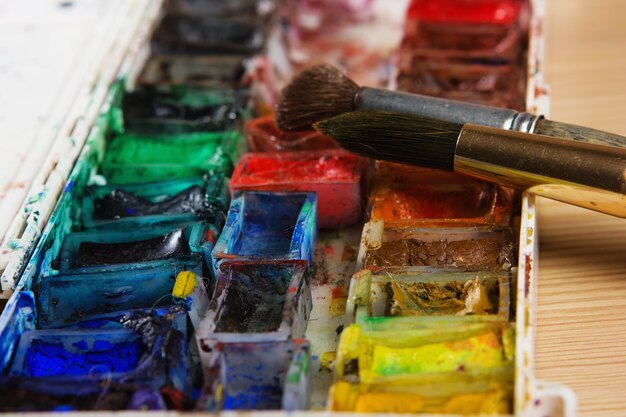 Photo pinceaux d'artistes et peintures à l'aquarelle sur palette