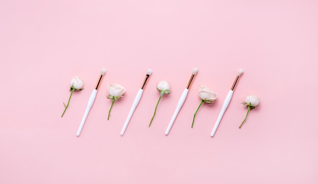 Pinceaux De Maquillage Et Fleurs Sur Fond Blanc. Copyspace De Vue Horizontale.