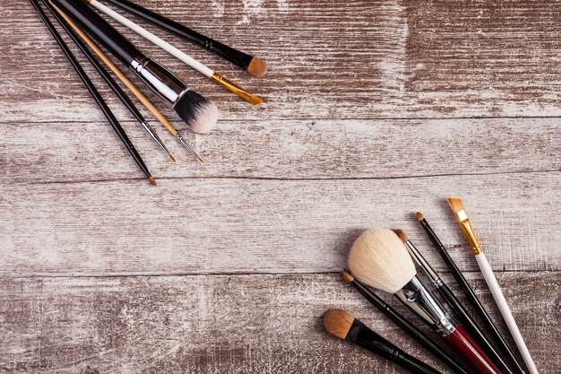 Pinceaux de maquillage sur l'image vue de dessus sur fond en bois Produits cosmétiques