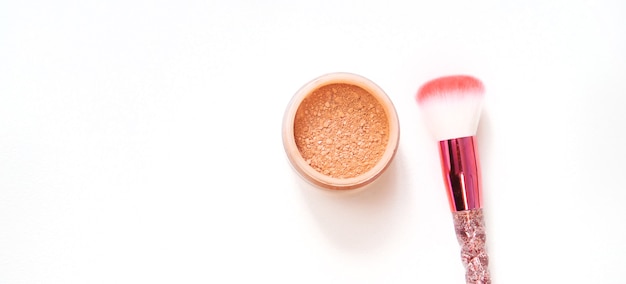 Pinceaux de maquillage et poudre sur fond blanc. Mise au point sélective.