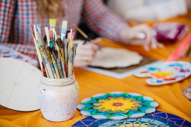 Les Pinceaux Et Les Peintures Des Mains Des Femmes S'appuient Sur Une Formation Artistique Pour Créer Le Mandala De La Vie