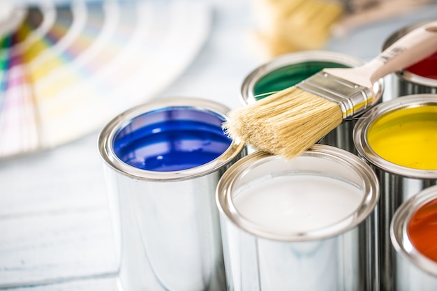 Pinceaux de pots de peinture et palette de couleurs sur table.