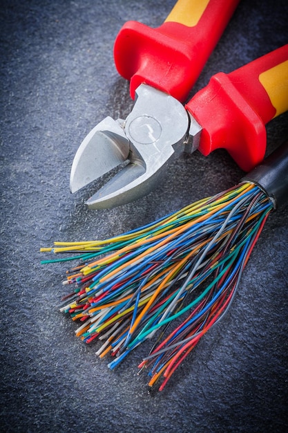 Pinces à fils électriques multicolores sur fond noir concept d'électricité