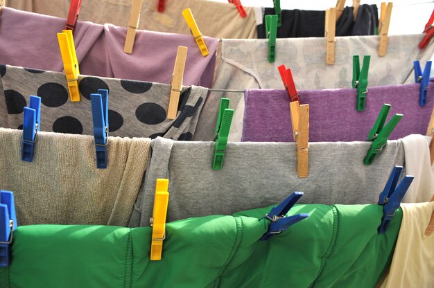 Des pinces à linge colorées maintiennent les vêtements sur une corde