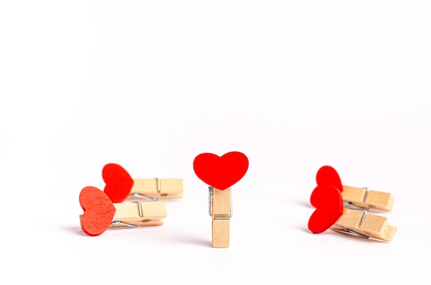 Pinces à linge décoratives avec des coeurs rouges pour la Saint-Valentin sur fond blanc